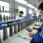 Inginerii inspectând arcuri ciur într-o unitate modernă de producție.